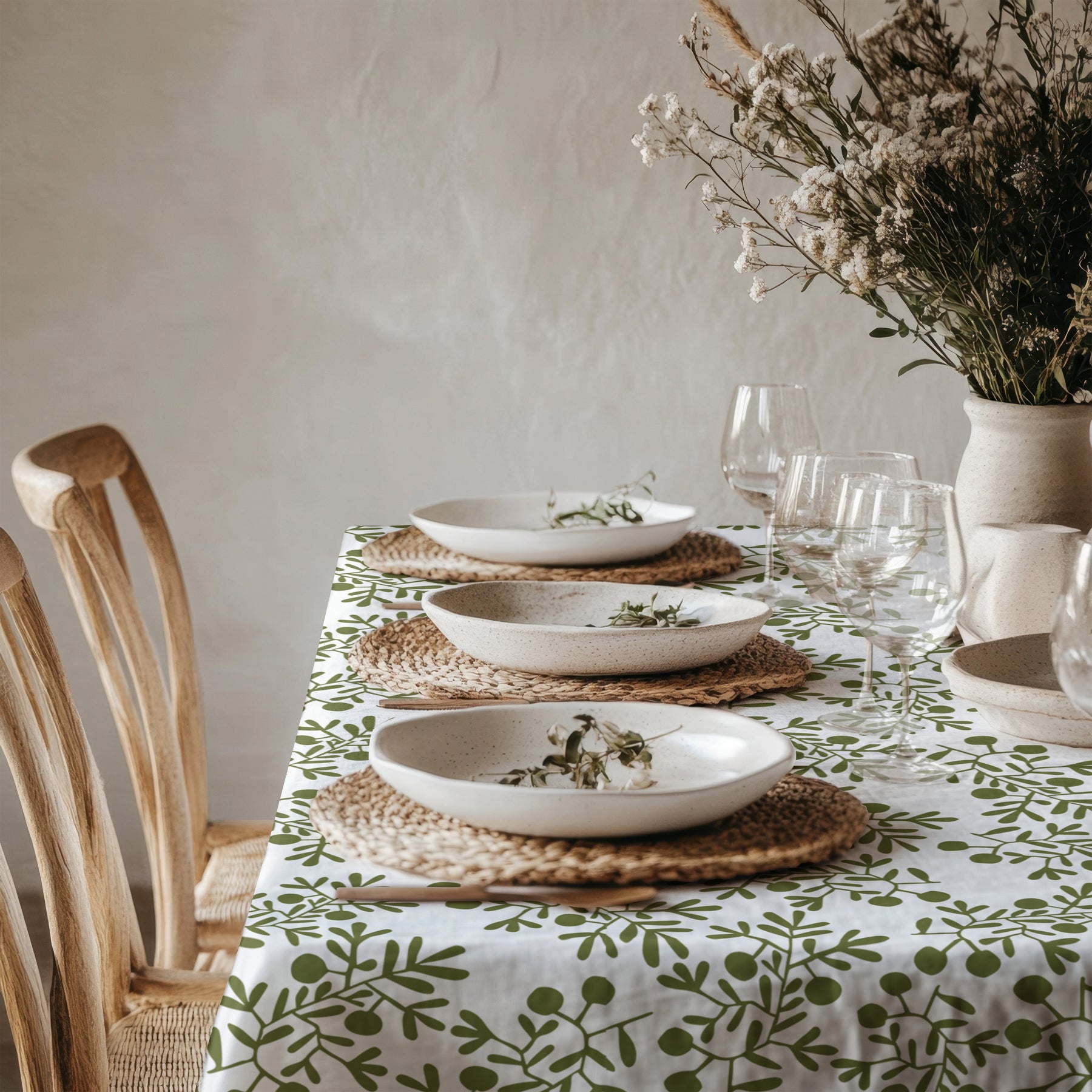 Olive green Mediterranean tablecloth styled on a modern dining table for a table linen buying guide.