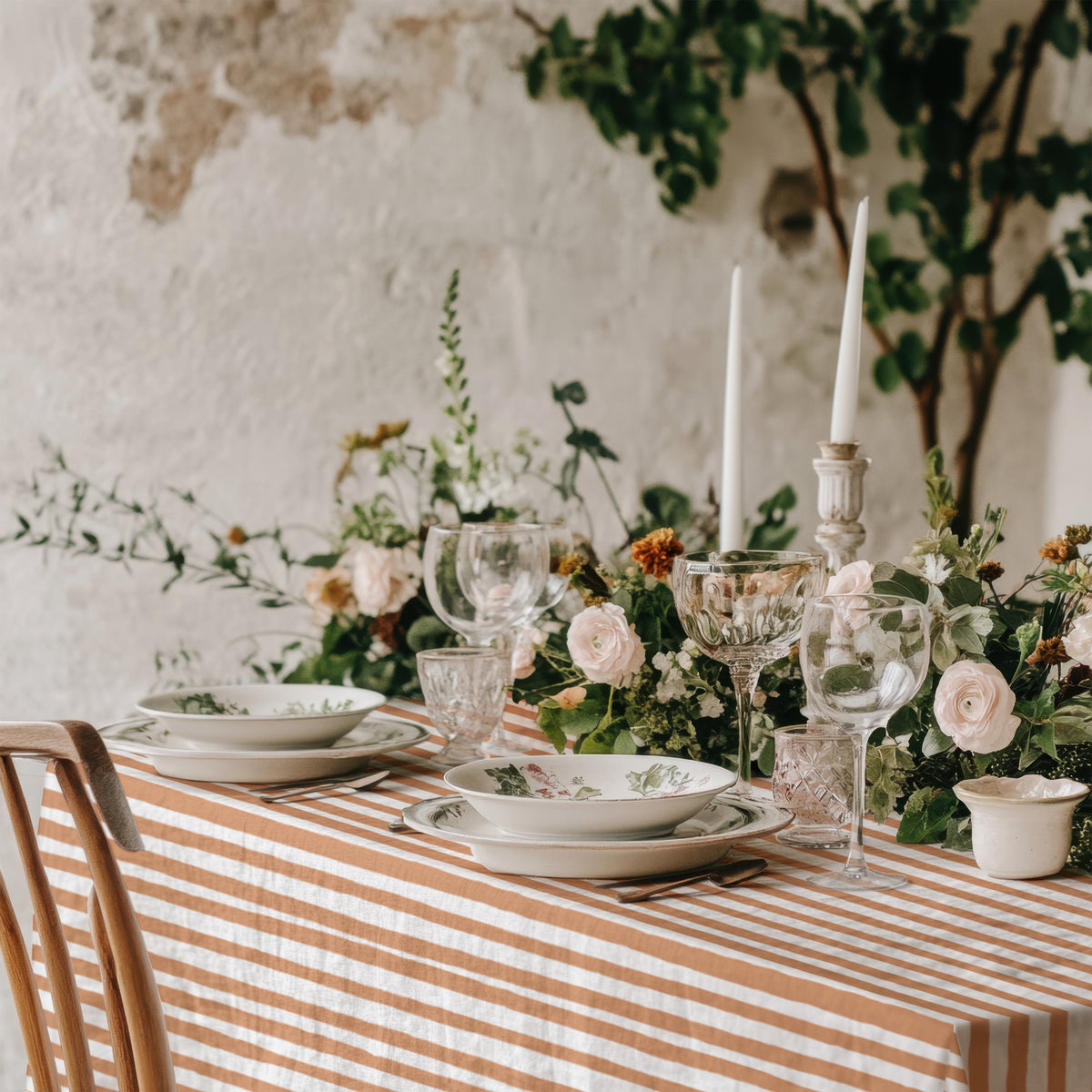 Terracotta and cream striped cotton tablecloth on a dining table, showing the drape to check before ordering