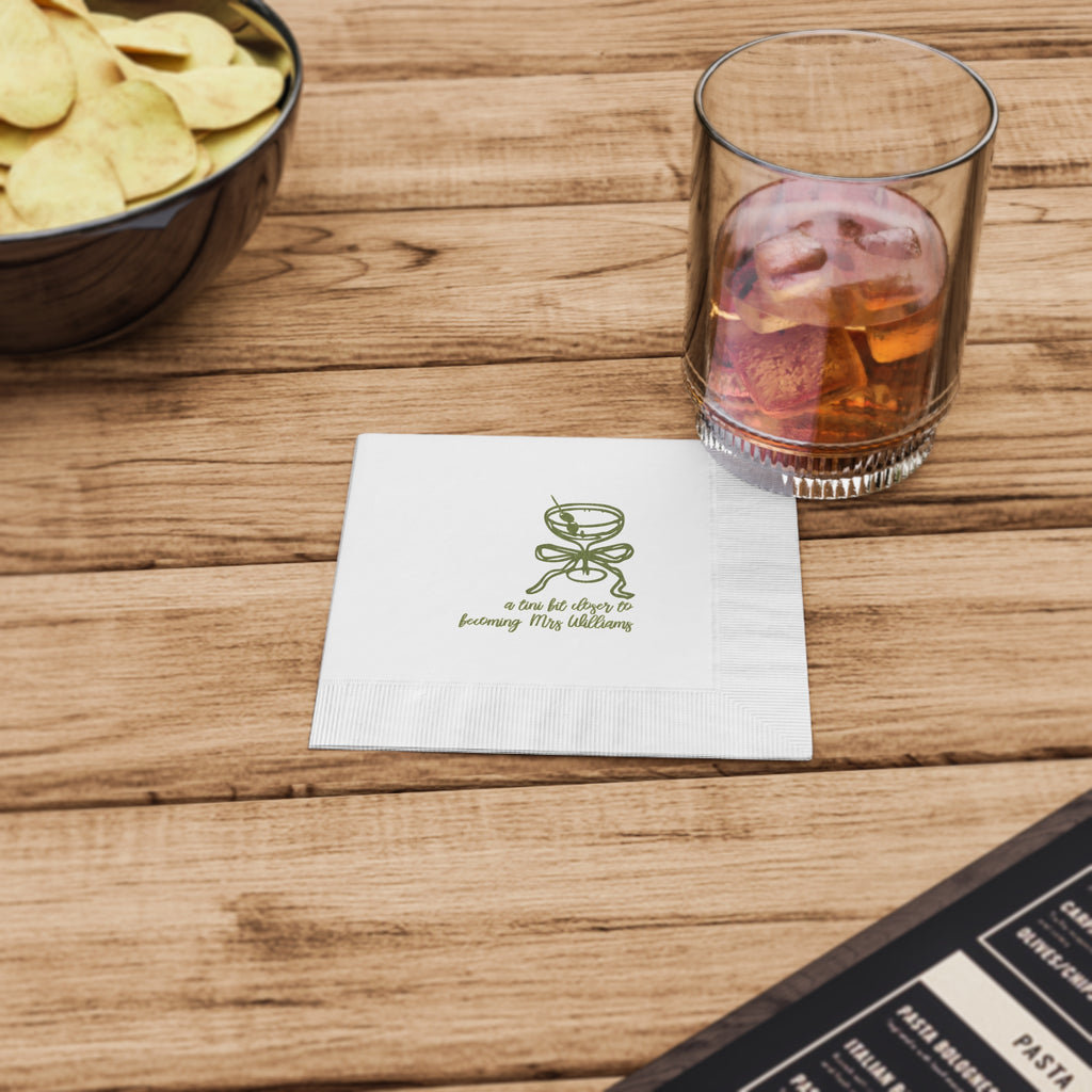 White three-ply beverage napkin with a martini glass and bow design, personalized for a chic bachelorette party.