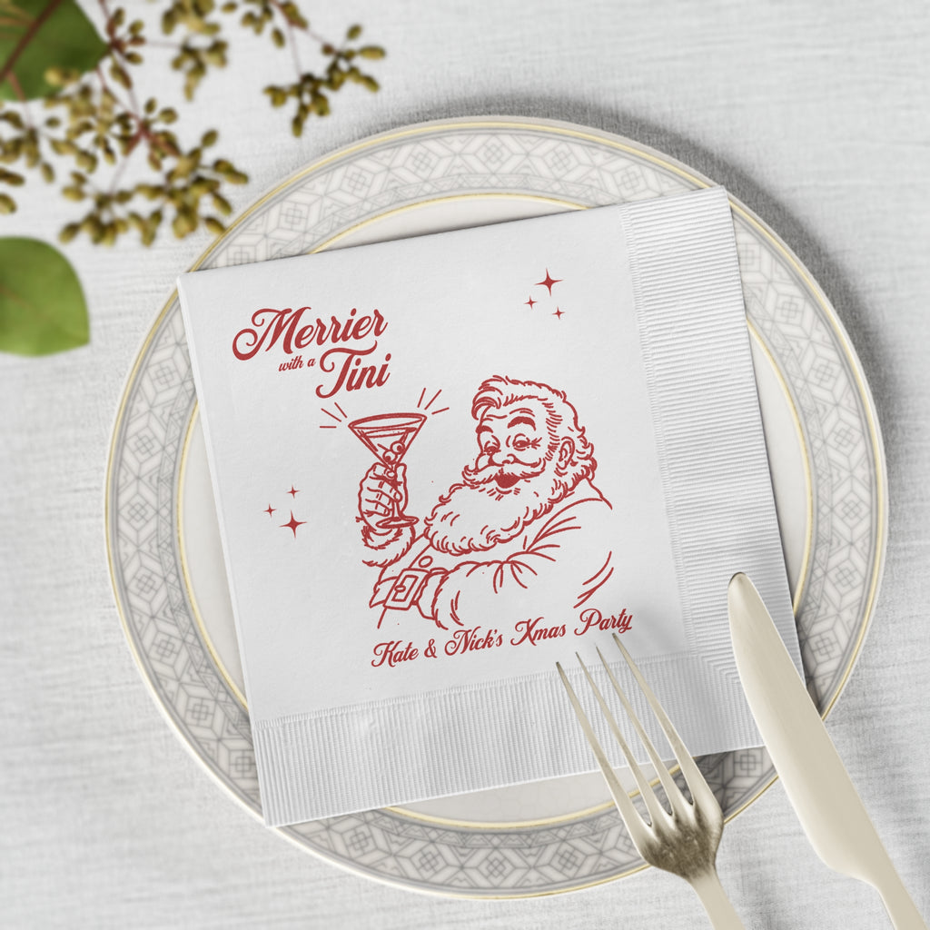 Merrier with a Tini personalised Christmas napkin styled for a festive cocktail party table with seasonal holiday decorations.