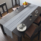 Elegant table setting with slate blue runner, white ceramic dishes, and clear glassware