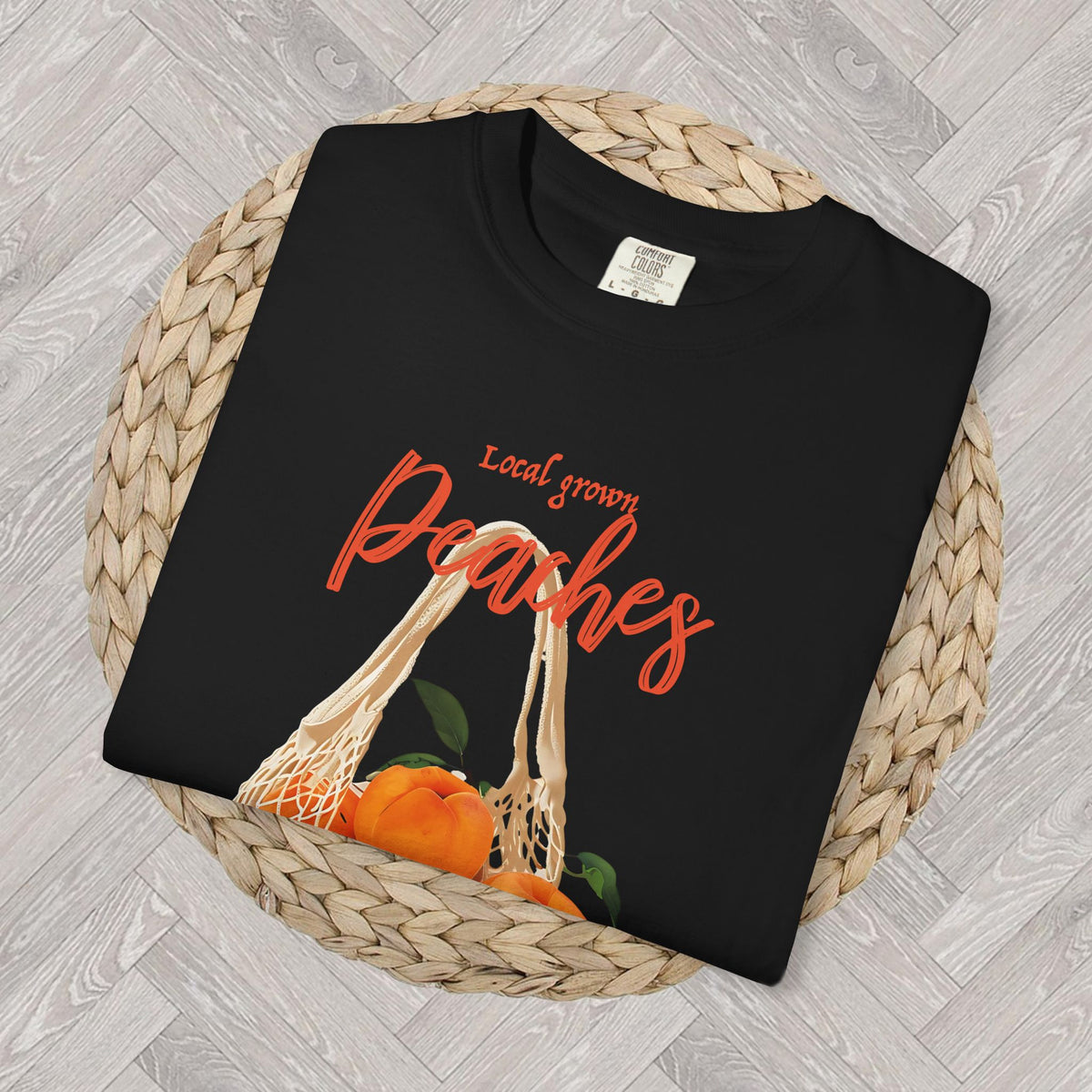 Folded Farm Fresh Peaches T-shirt showing the vintage peach graphic, market produce bag, green leaves, and “Farm Fresh” lettering.