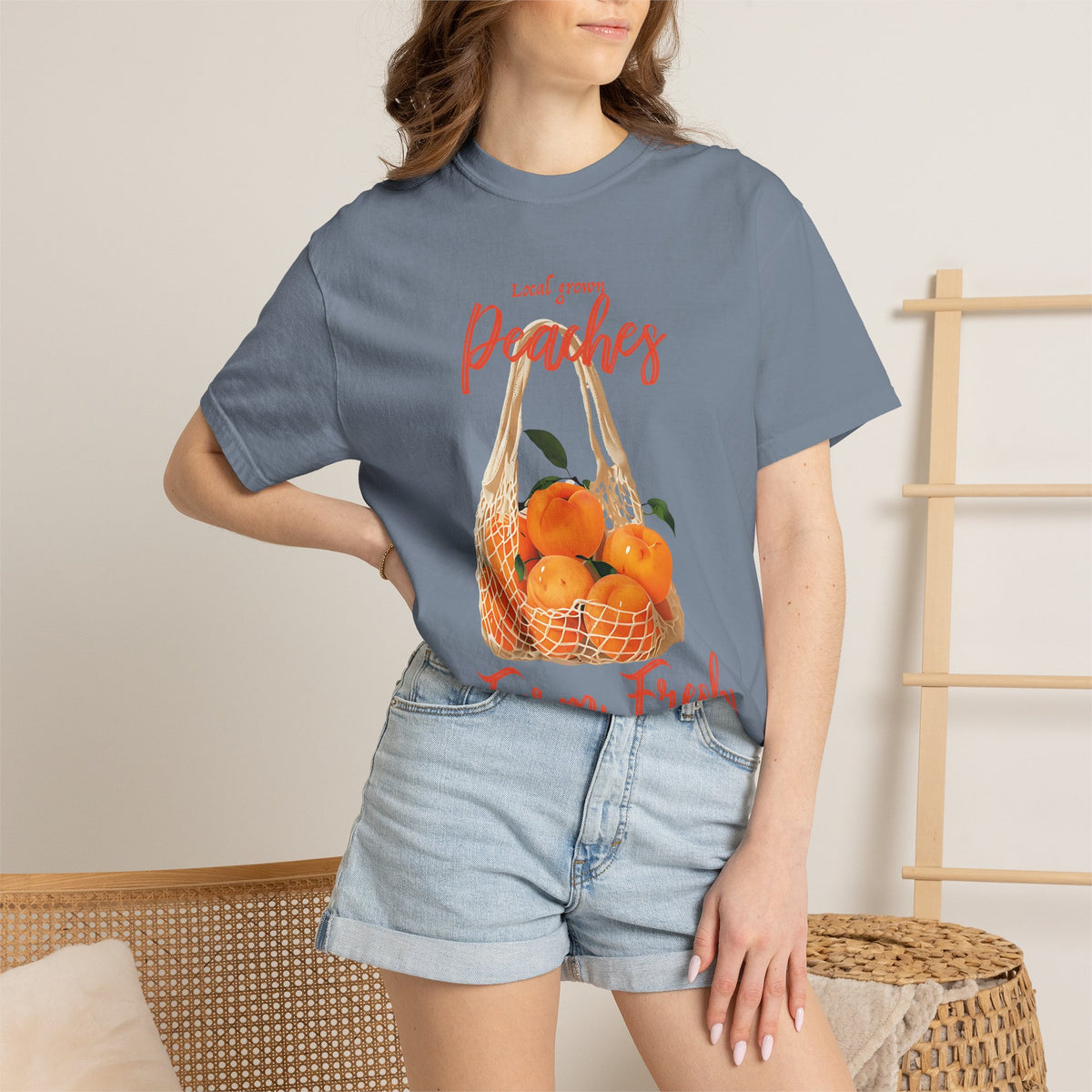 Lifestyle close-up of the Farm Fresh Peaches graphic tee highlighting the soft vintage-inspired fabric and colorful peach illustration.