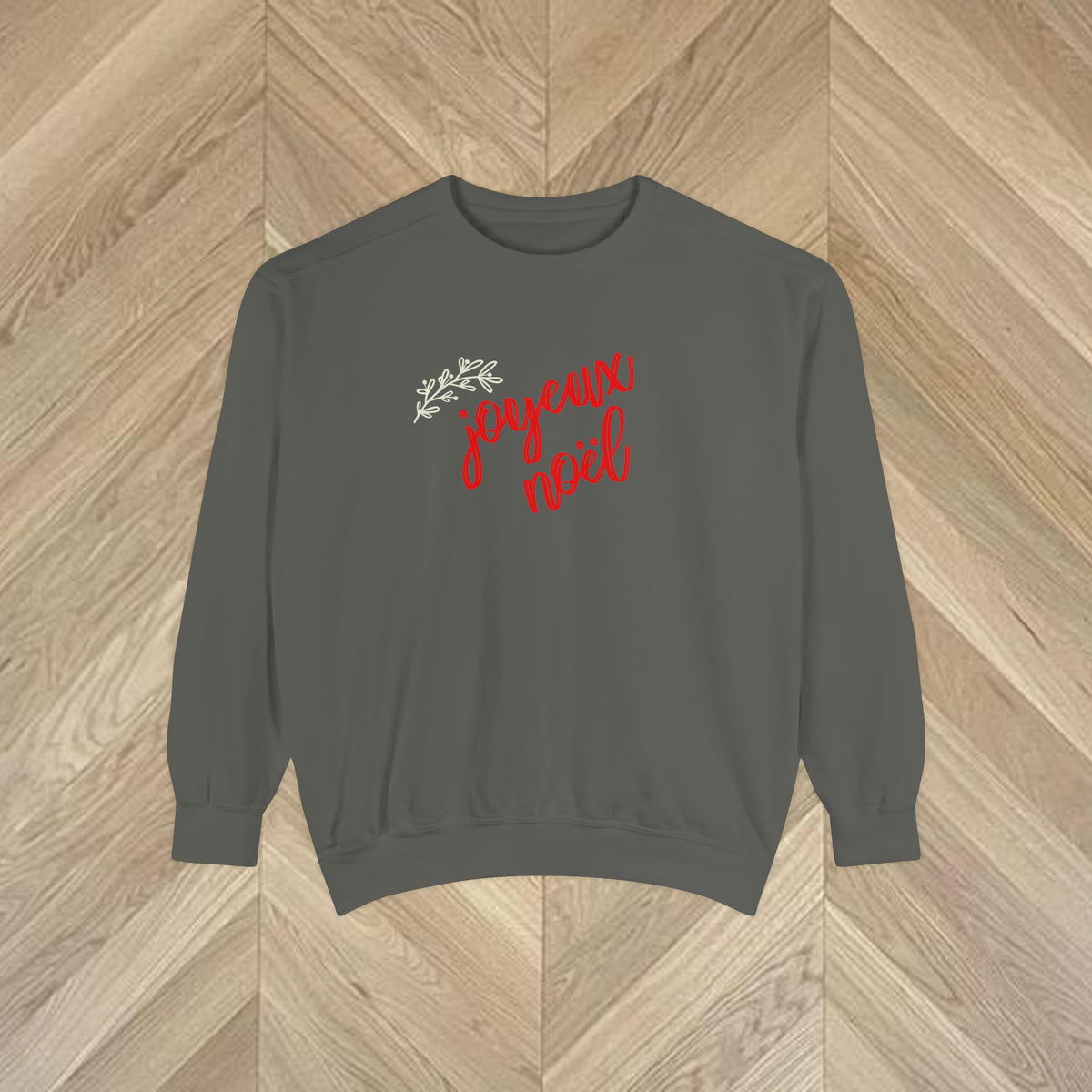 Close-up of the Joyeux Noël lettering and delicate botanical print on a French-inspired Christmas sweatshirt