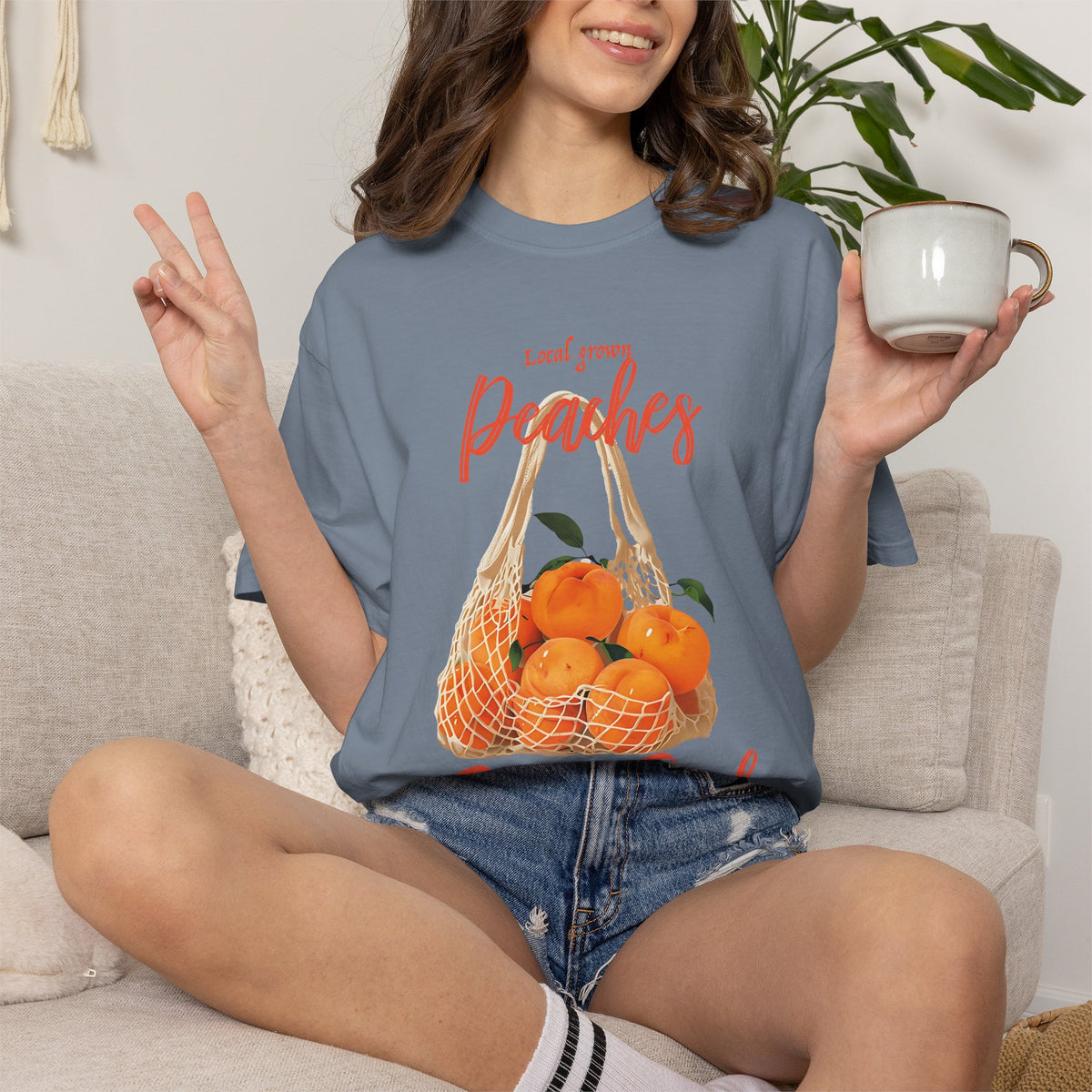 Close-up of a folded Farm Fresh Peaches T-shirt highlighting the peach graphic, leafy details, and vintage-style lettering.