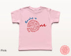 Pink toddler birthday t-shirt featuring personalized ‘Amelia is One’ pizza design in red and blue, cute Italian pizza party shirt for first birthday celebration.