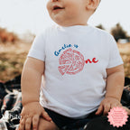 Baby wearing white custom pizza party shirt with personalized ‘Amelia is One’ design, Italian-themed first birthday outfit for toddlers and infants.