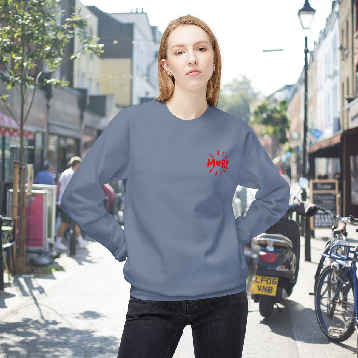 Front view of More Amore Por Favour colourful graphic sweatshirt in Stone Blue with a small upper left chest heart and colourful back artwork.
