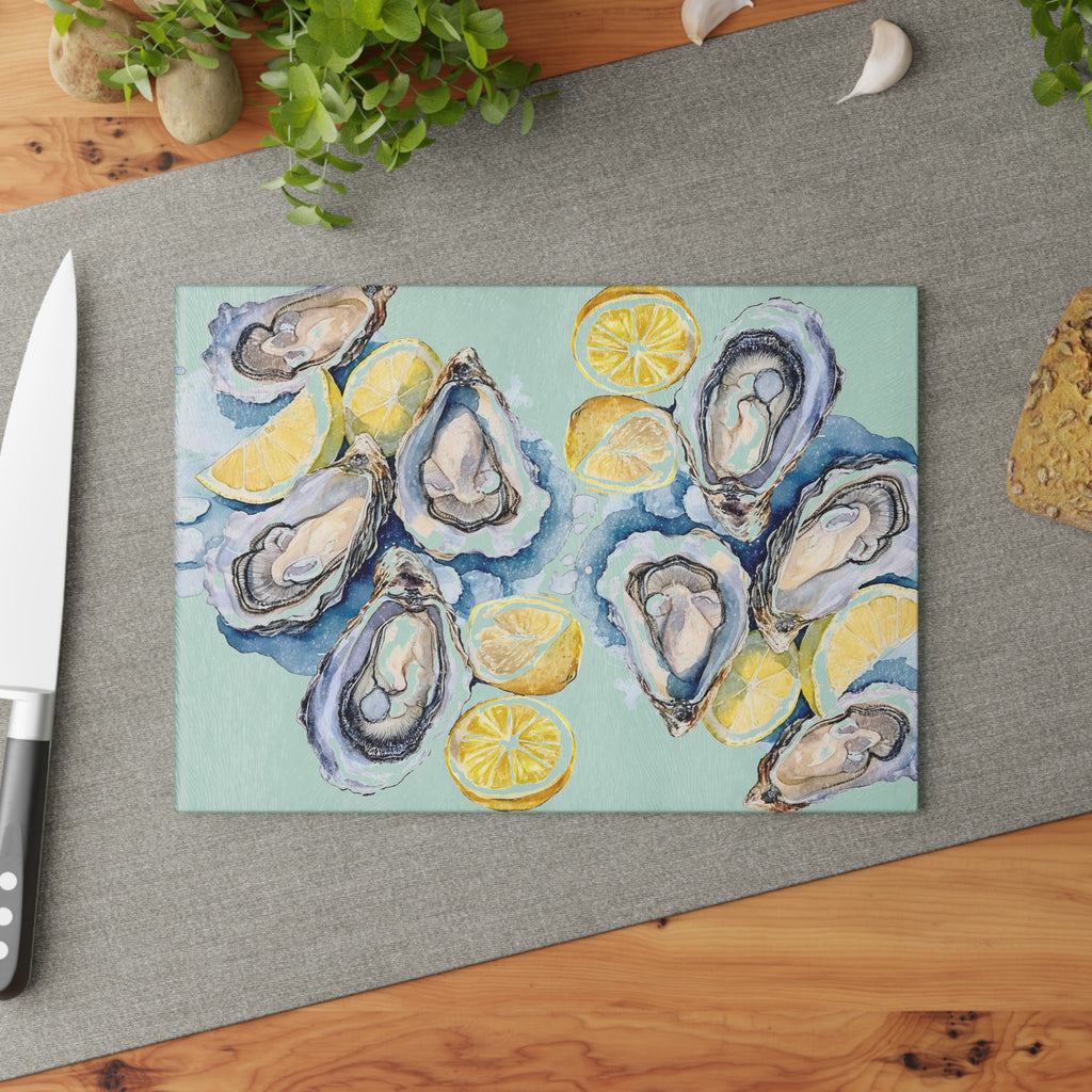 Textured tempered glass cutting board with watercolor oyster artwork and lemon illustrations for coastal home decor
