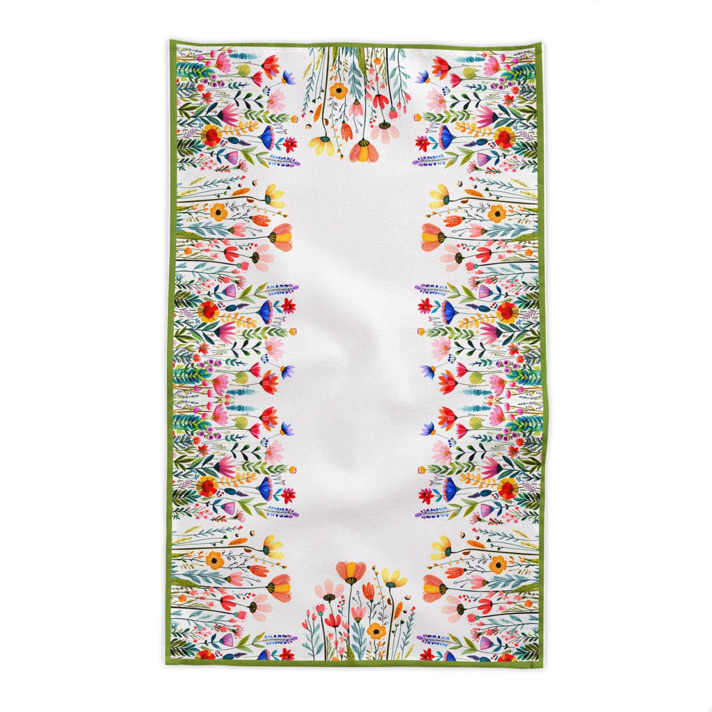 European summer inspired dining scene featuring Mediterranean botanical tablecloth with flowers, ceramics, and natural décor