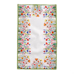 European summer inspired dining scene featuring Mediterranean botanical tablecloth with flowers, ceramics, and natural décor
