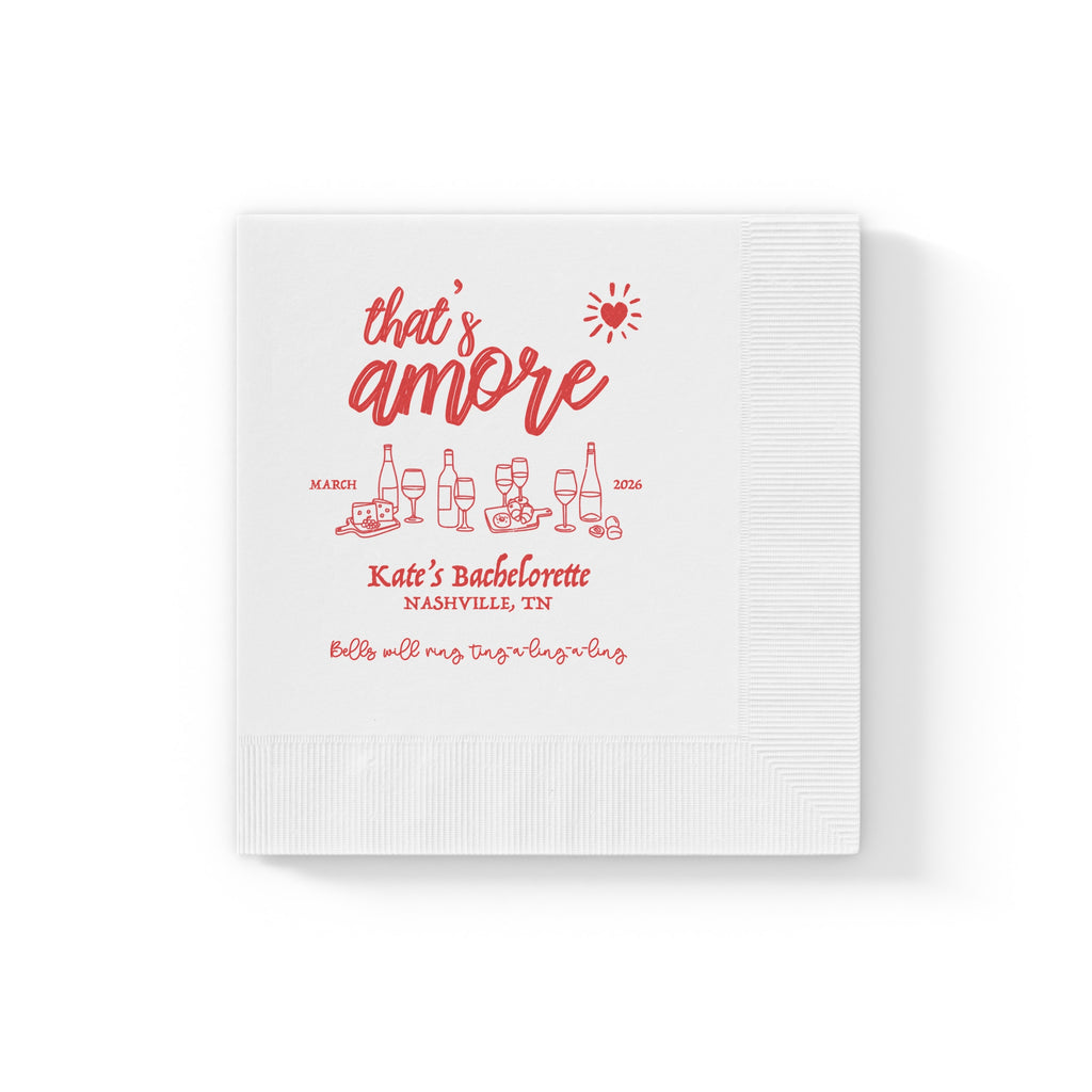 Personalized bridal shower napkin with That's Amore design, custom bride's name, location, and event date printed in red.