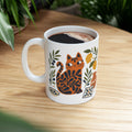 Ceramic tea mug featuring an artistic cat illustration with lemons, pottery, and Mediterranean tile motifs.