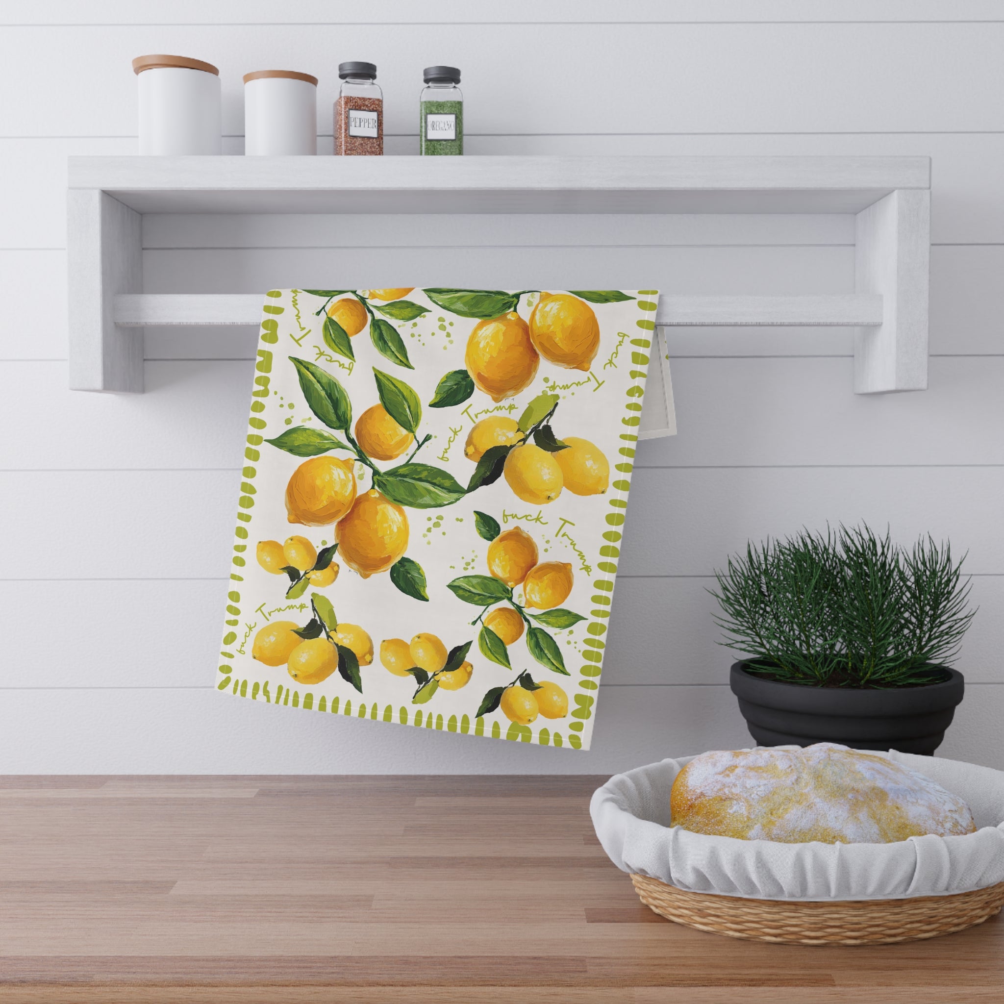 Watercolor lemon kitchen towel styled as decorative wall art in rustic kitchen setting