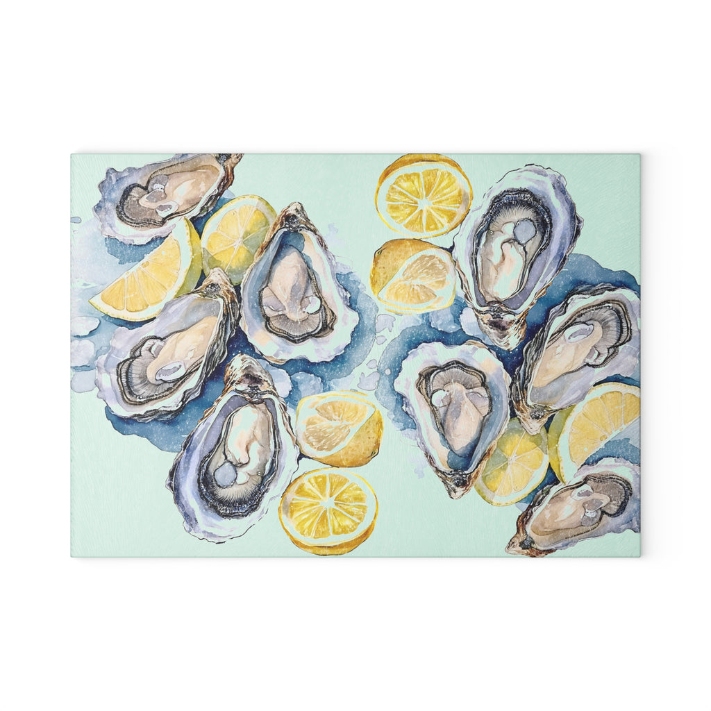 Decorative oysters and lemons glass cutting board styled in a coastal kitchen setting with relaxed seaside charm