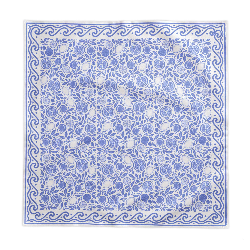 Blue and white fruit-patterned tablecloth styled for an elegant dining table