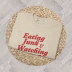 Close-up view of a festive retro Christmas sweatshirt with humorous movie-night text and seasonal styling.