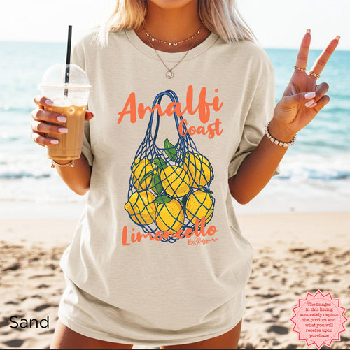White Amalfi Coast Lemoncello graphic t-shirt featuring illustrated yellow lemons in a blue net bag and Italian-inspired lettering