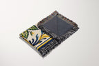 Close-up view of woven cotton texture and colorful fringed edges on a Mediterranean lemon blanket