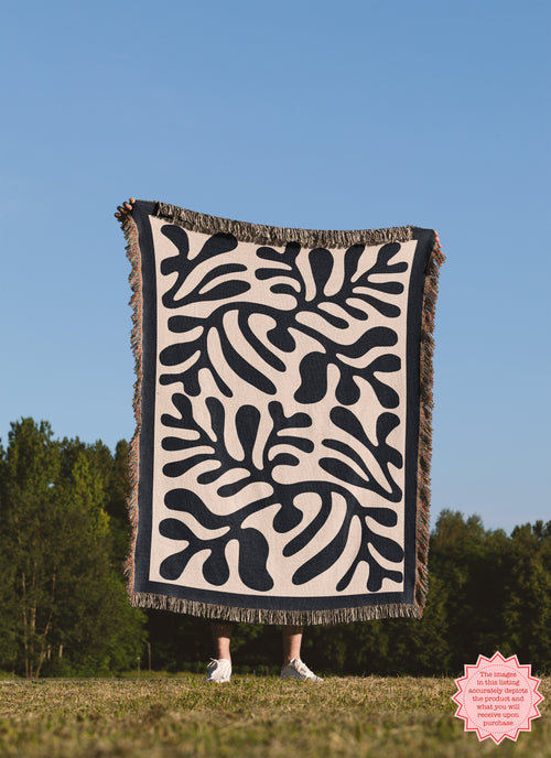 Close-up of the Black Matisse Pattern Woven Blanket, featuring bold abstract shapes and vibrant fringed edges.