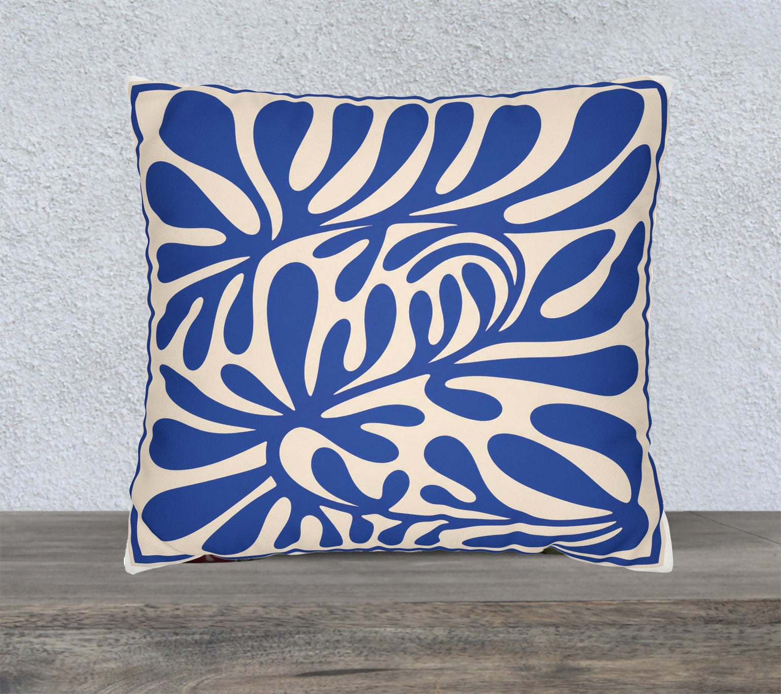 Blue Mediterranean abstract faux suede cushion featuring oversized botanical cut-paper inspired artwork on a square decorative throw pillow.
