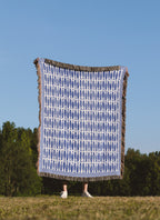 Blue and white fish pattern blanket displayed as a decorative coastal home accent with textured woven threads