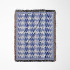 Ocean-inspired woven blanket with repeating blue fish motifs for coastal, boho, and seaside interiors