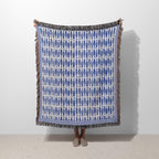 Blue Fish woven blanket featuring a repeating ocean fish pattern in blue and ivory with colorful fringed edges