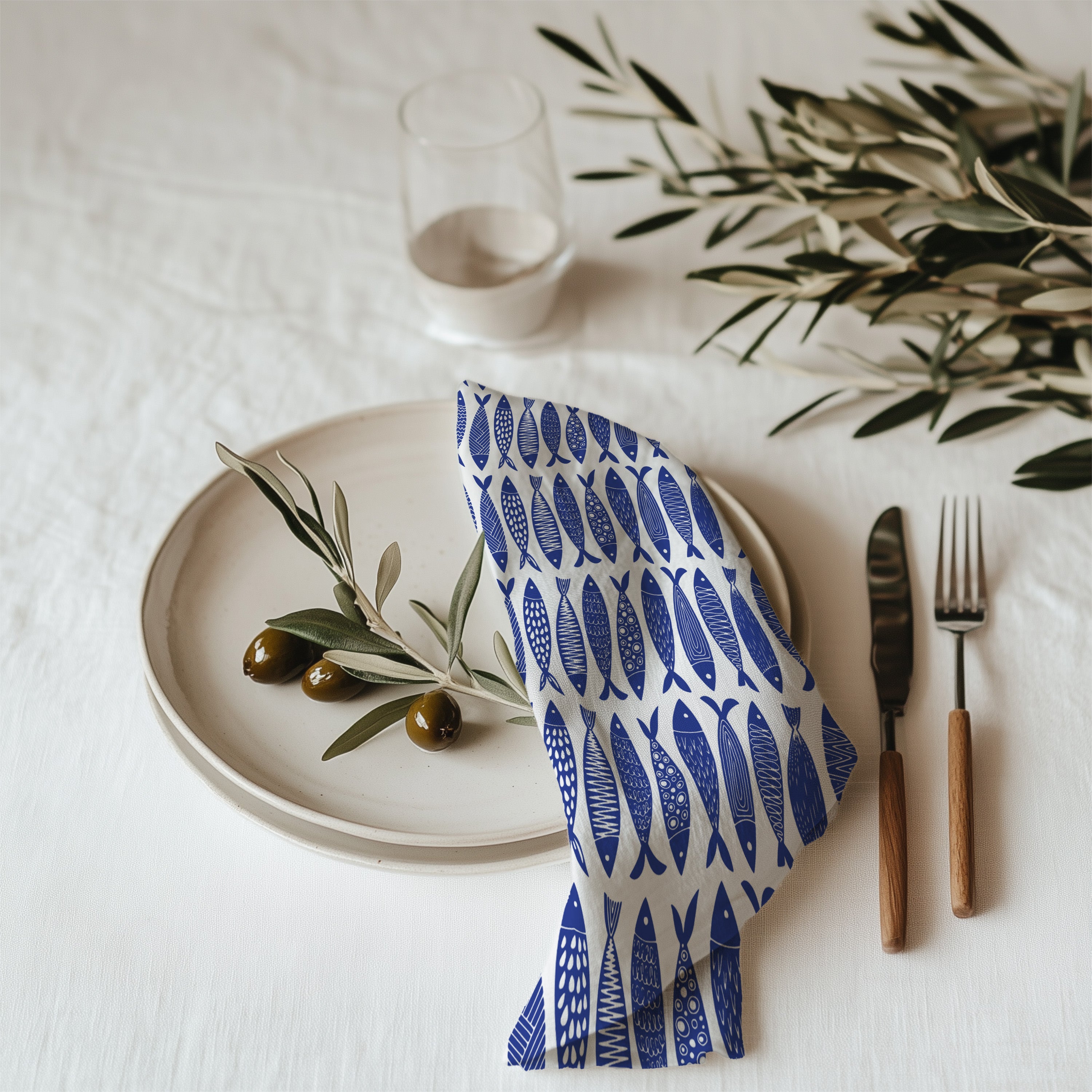 Blue fish coastal cotton twill cloth napkin displayed on dining table with nautical ocean-inspired decor