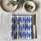 Single blue fish dinner napkin folded on table showcasing one-sided ocean pattern print and premium reusable cotton fabric