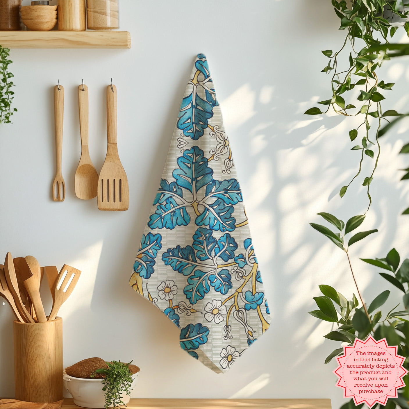 Cotton tea towel with blue botanical leaf pattern laid flat on marble surface