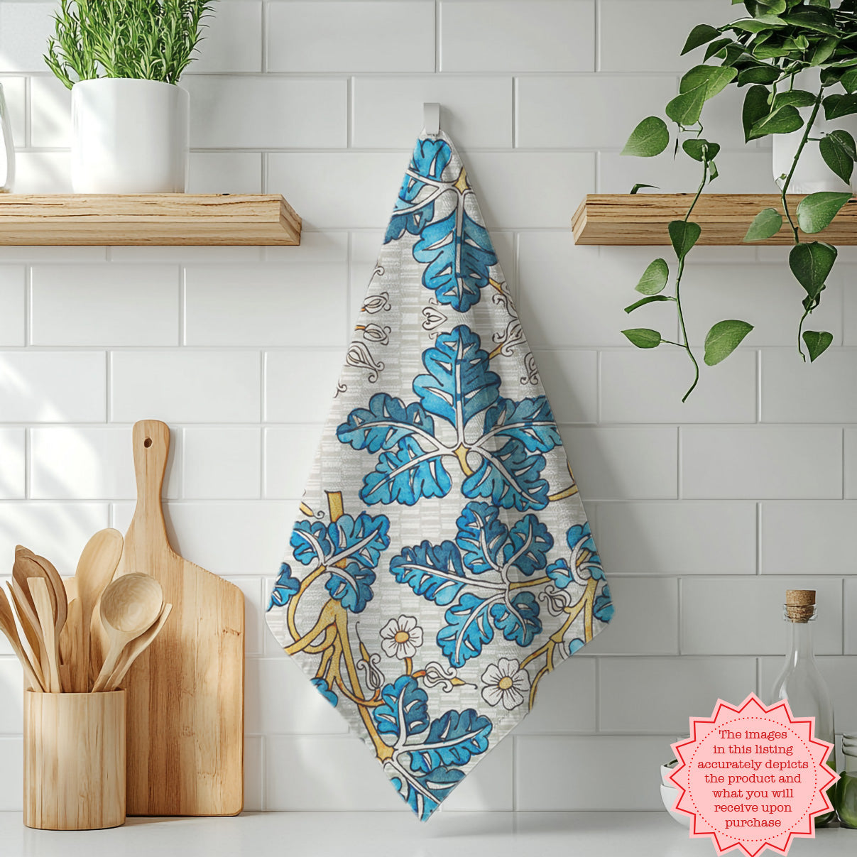 Decorative blue botanical tea towel styled on countertop with kitchen utensils