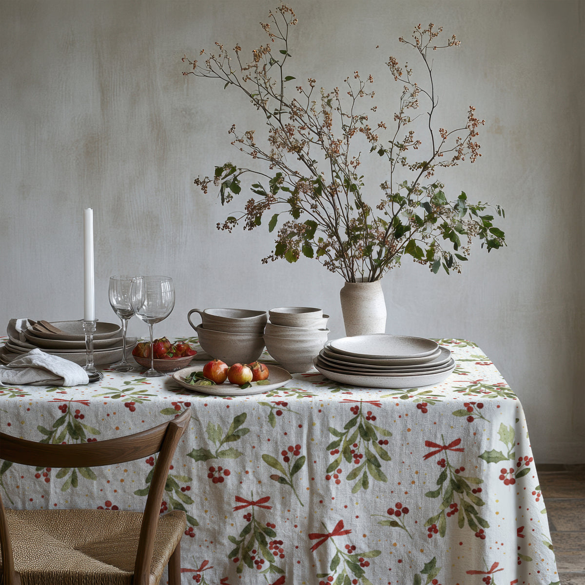 Festive table setting featuring Christmas mistletoe table linen paired with elegant dinnerware and seasonal decorations.