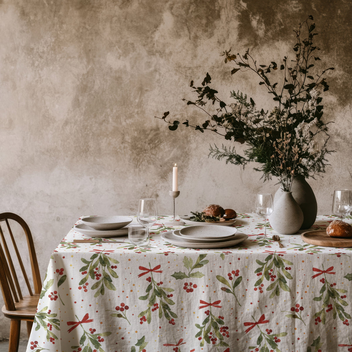 Christmas dining table styled with a botanical mistletoe tablecloth, creating a natural and festive seasonal look.