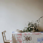 Colourful Mediterranean cotton table linen featuring champagne glasses, wine bottles, cocktails and festive hand-drawn artwork