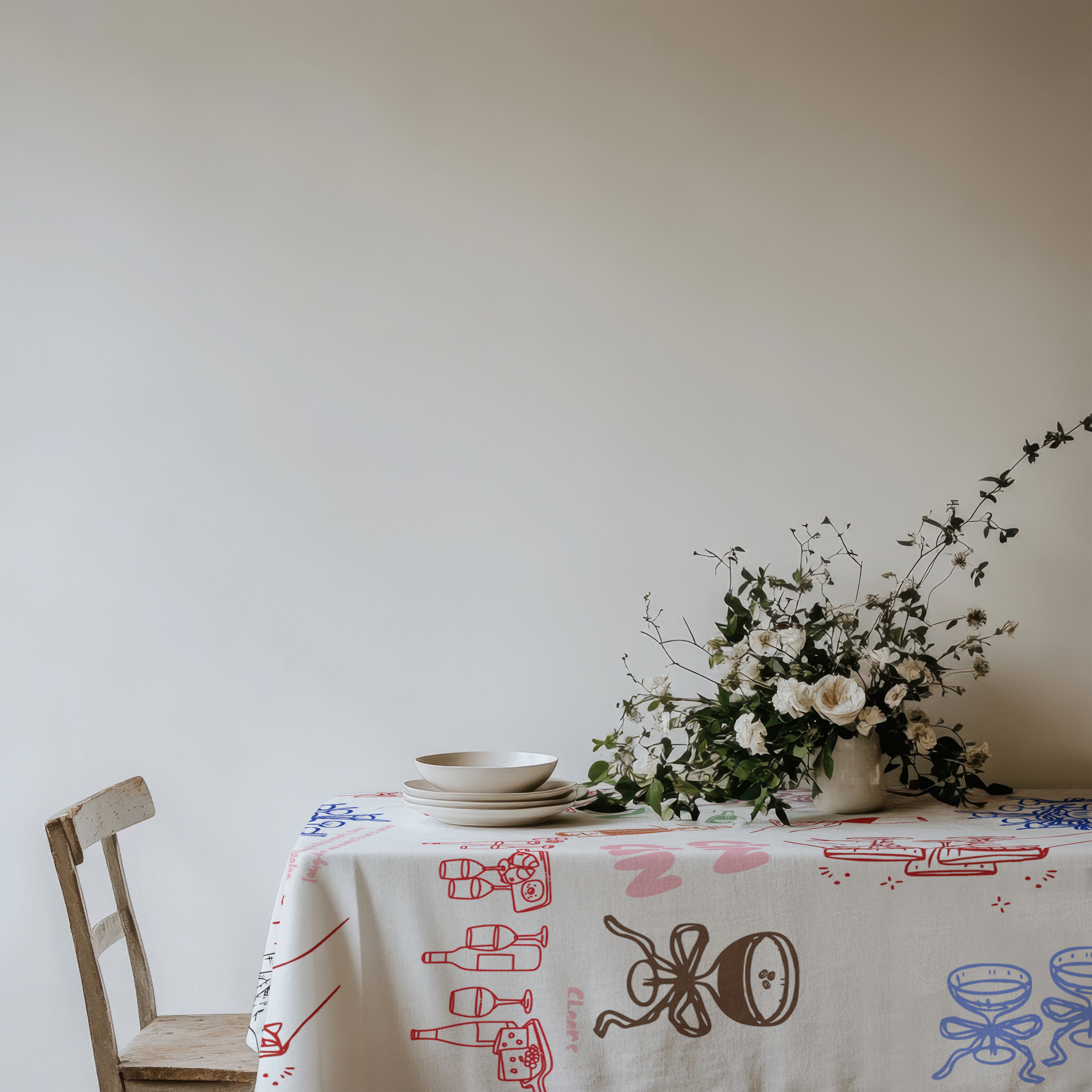 Colourful Mediterranean cotton table linen featuring champagne glasses, wine bottles, cocktails and festive hand-drawn artwork