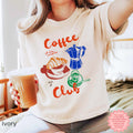Ivory Coffee Club crop top with a playful design of coffee-related illustrations, ideal for coffee enthusiasts.