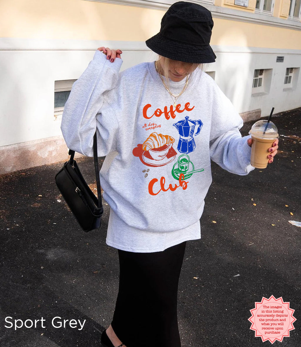 Sport grey Coffee Club sweatshirt featuring a vibrant, retro coffee graphic of a croissant, coffee cup, and espresso machine. Stylish and comfortable.