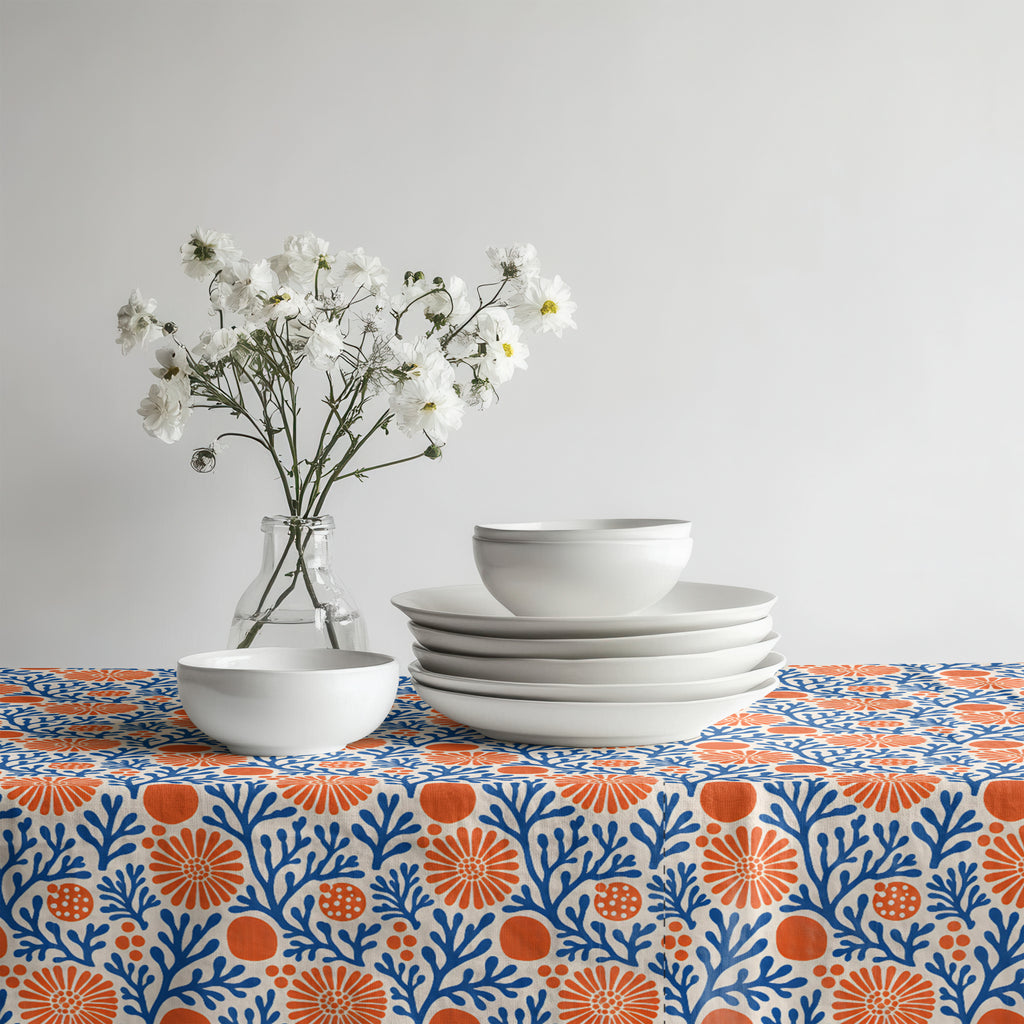 Mediterranean Coral Reef Tablecloth featuring cobalt blue coral branches and terracotta florals styled with white ceramic dinnerware.