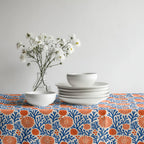 Mediterranean Coral Reef Tablecloth featuring cobalt blue coral branches and terracotta florals styled with white ceramic dinnerware.