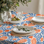 Mediterranean dining table featuring a coral reef tablecloth paired with natural ceramics and minimalist décor.