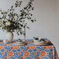 Mediterranean coastal tablecloth styled for everyday dining with white dinnerware and fresh seasonal flowers.