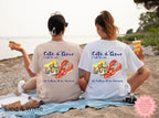 Sand, White-colored Cote d’Azur lobster and oysters watercolor t-shirt, casual coastal style, worn by a person descending wooden stairs to the beach, perfect for lobster roll enthusiasts and summer outfits.