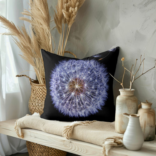 Detailed Dandelion Cushion featuring a vibrant dandelion design on a black background. The cushion is styled on a neutral-colored wooden bench with a vase of dried pampas grass and pottery.