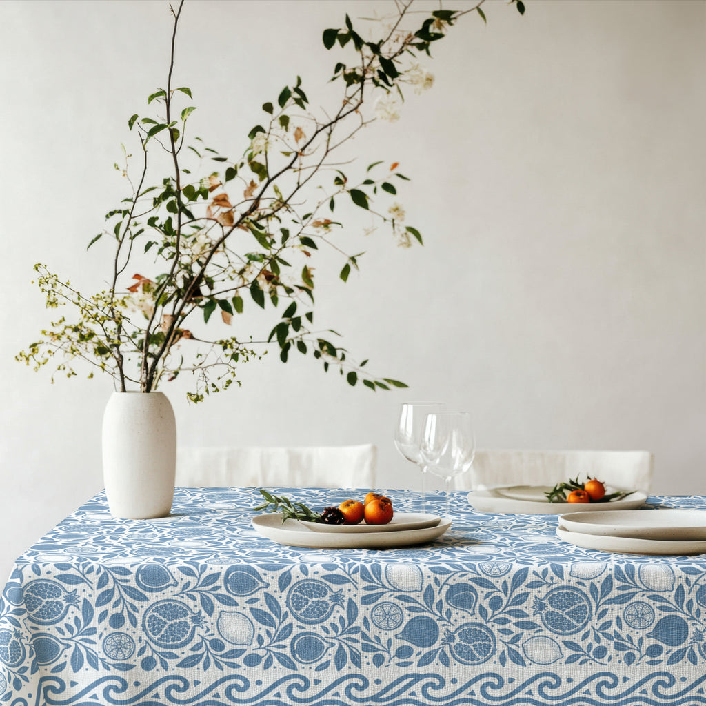 Dusty blue botanical tablecloth featuring pomegranates, figs, lemons and foliage