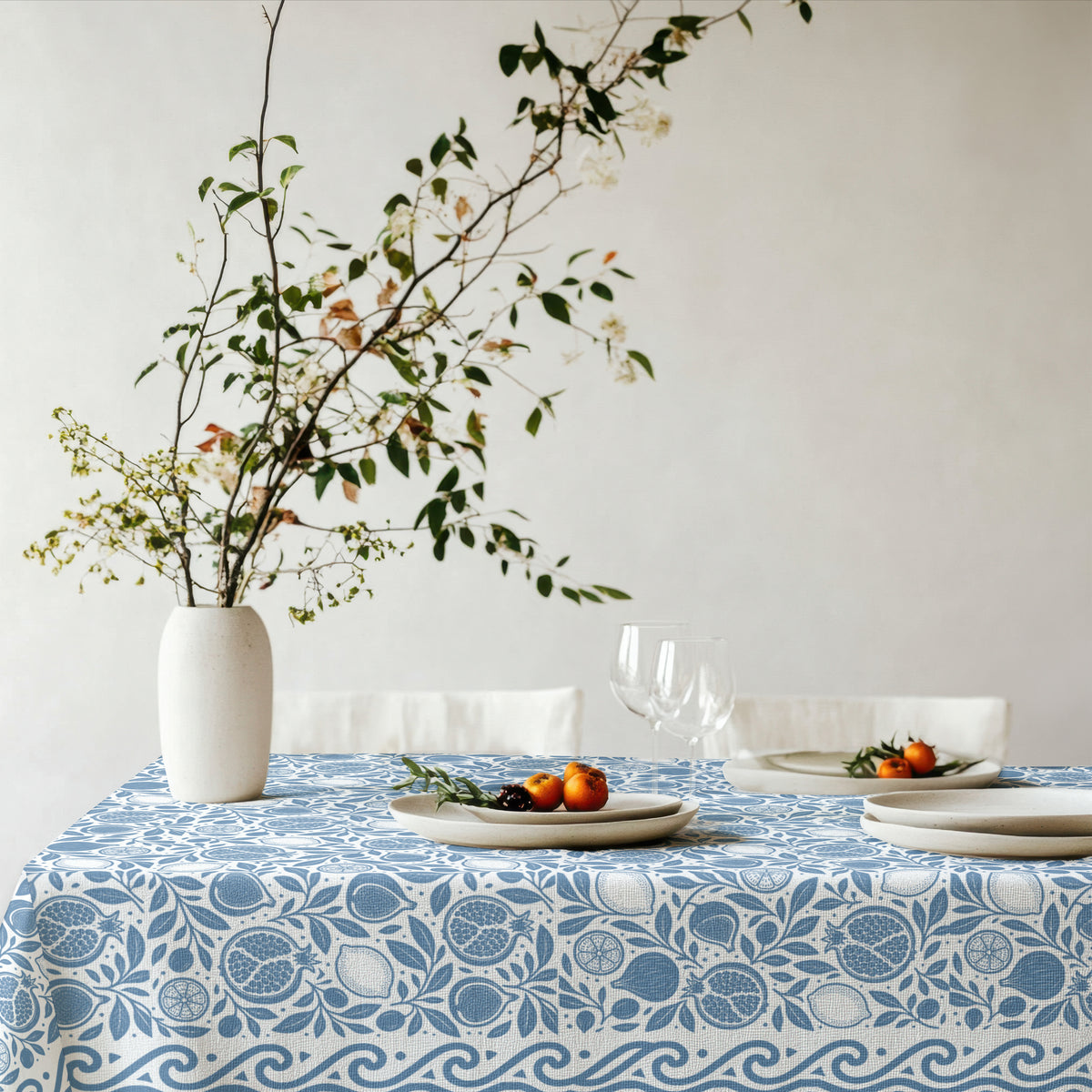 Dusty blue botanical tablecloth featuring pomegranates, figs, lemons and foliage
