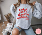Retro Christmas crewneck sweatshirt featuring “Eating Junk & Watching Rubbish” in a fun vintage-inspired design, perfect for a cosy holiday movie night.