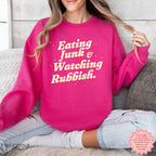 Model wearing a funny Christmas crewneck sweatshirt with retro lettering, surrounded by cosy holiday movie-night details.