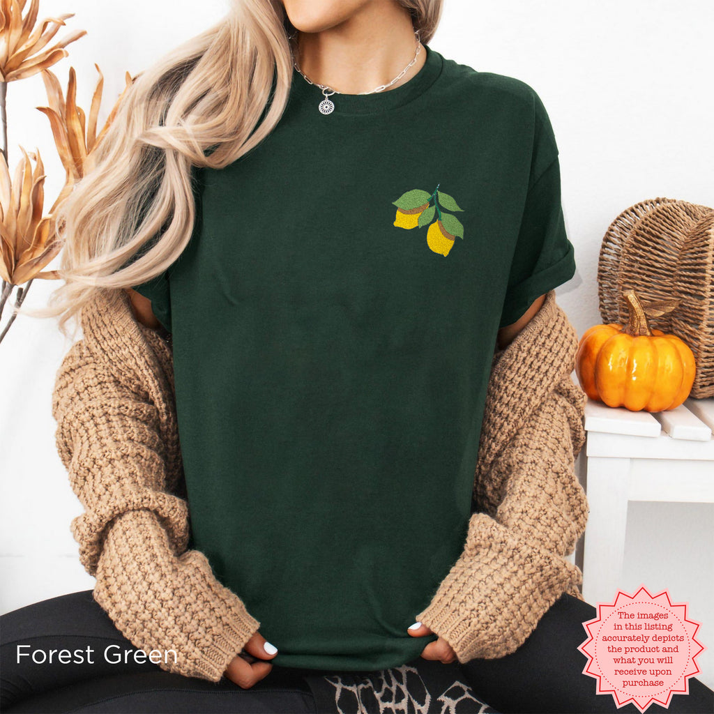 Close-up view of lemons and green leaves embroidered on the chest of a t-shirt