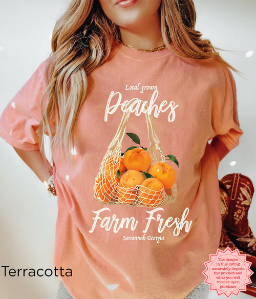 Front view of the Farm Fresh Peaches graphic T-shirt showing the full vintage peach illustration and “Savannah Georgia” lettering on a relaxed-fit garment-dyed tee.